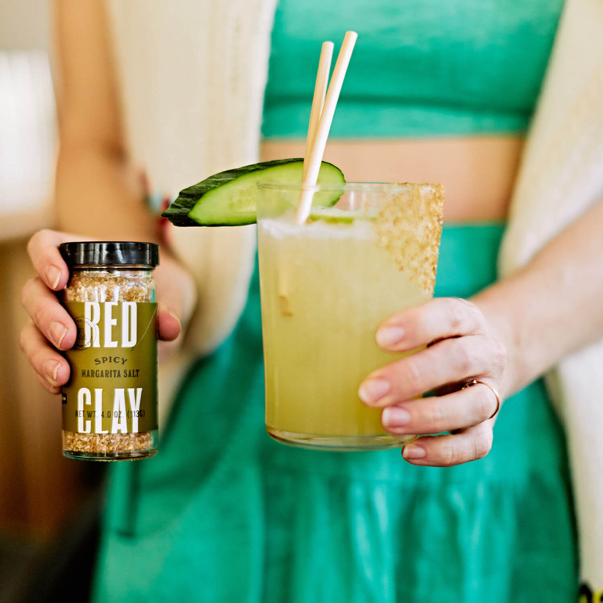 Woman holding the Spicy Margarita Salt in one hand and a Margarita in the other.