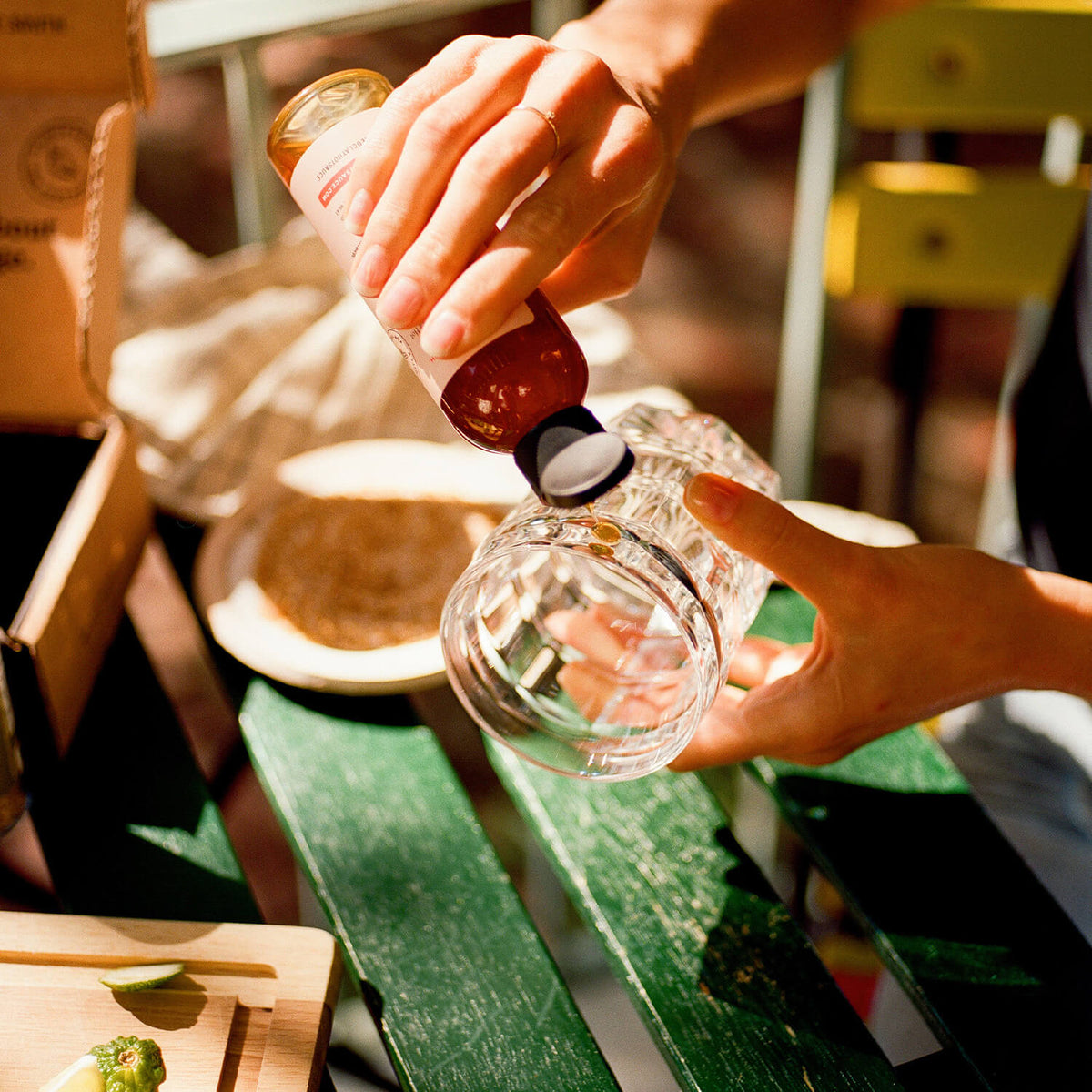 Pouring the Spicy Peach Honey on the rim of a glass to dip into the spicy margarita salt